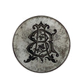 Decorative metal jewellery impression die with intricate black design on a white background