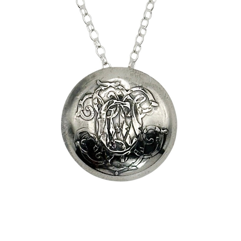 Silver necklace with a C on a round pendant on a white background