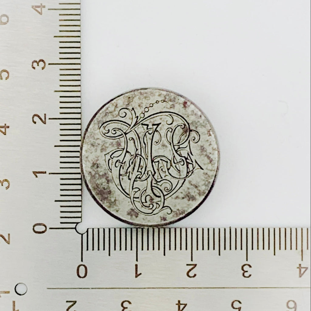 jewellery impression die for handmade jewellery in NottinghamC with engraved design next to a ruler on a white background