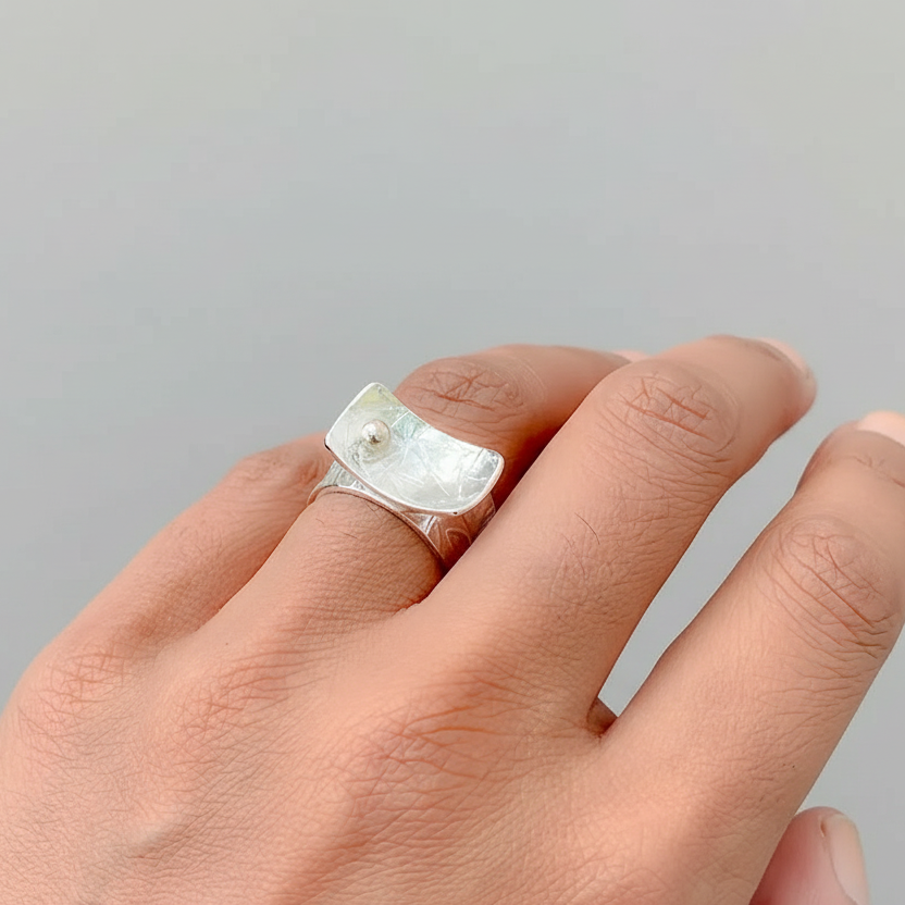 Hand wearing a silver and gold statement ring with an 18ct gold ball sustainable bespoke jewellery in Nottingham