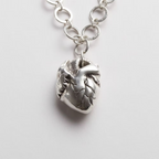 Solid silver anatomical heart pendant on a handmade chain against a white background, sustainably made by Bottlebee in Nottingham