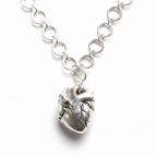 Handmade bespoke silver necklace with an anatomical heart shaped pendant on a white background