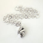 Silver handmade chain necklace with a anatomical heart shaped pendant on a white background, the jewellery is sustainable and made by Bottlebee in Nottingham