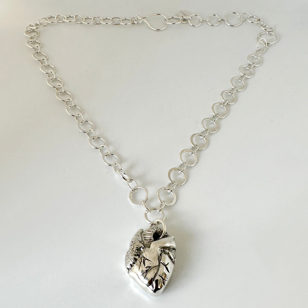 Solid silver anatomical heart pendant on a handmade chain with a handmade clasp against a white background, sustainably made by Bottlebee in Nottingham