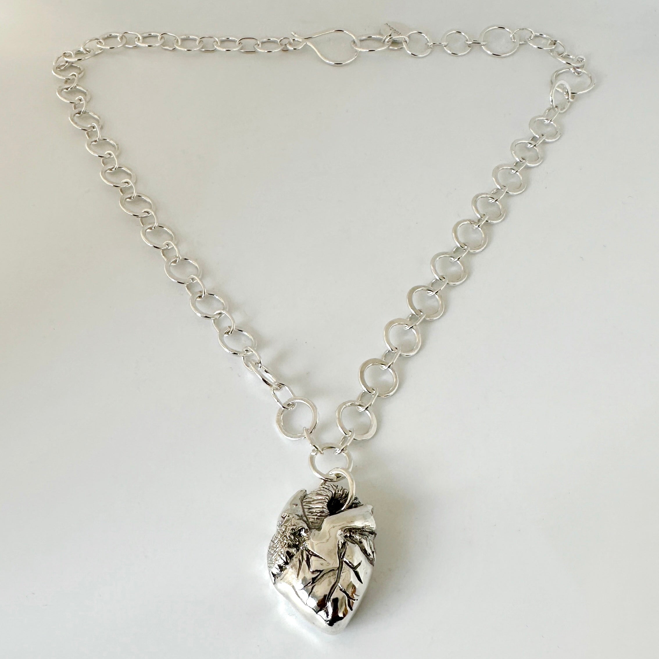Solid silver anatomical heart pendant on a handmade chain with a handmade clasp against a white background, sustainably made by Bottlebee in Nottingham