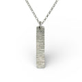 Silver necklace with a rectangular bark textured pendant on a white background