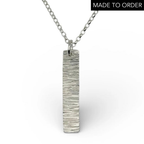 Bespoke handmade sterling silver necklace with a textured pendant like a hammered bark on a white background handmade jewellery by Bottlebee in Nottingham
