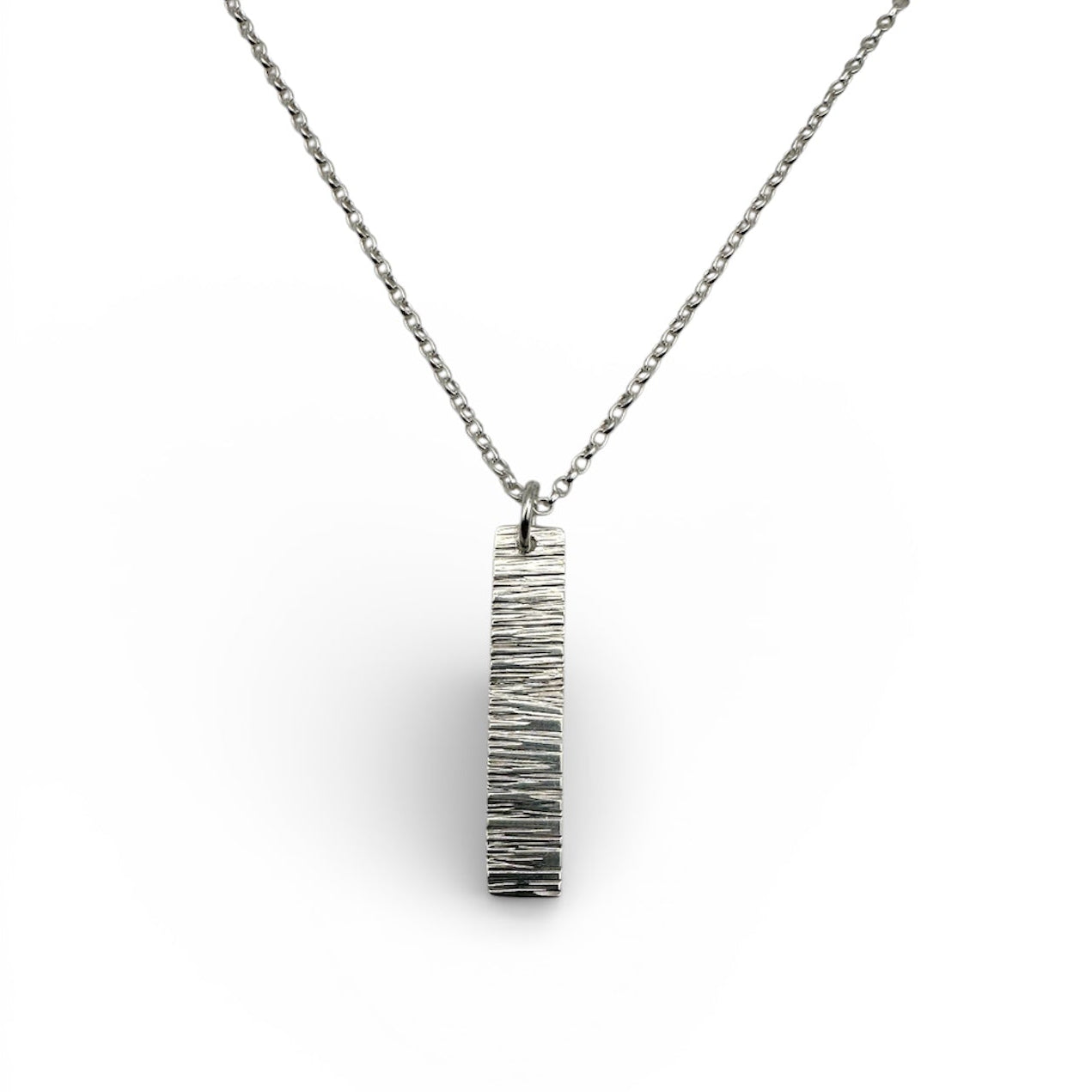 Silver necklace with a bark textured pendant on a white background sustainable made by Bottlebee in Nottingham