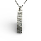 handmade solid silver necklace with a bark textured pendant on a white background