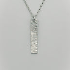 Silver pendant and belcher chain necklace on a grey background handmade by bottlebee who makes bespoke jewellery