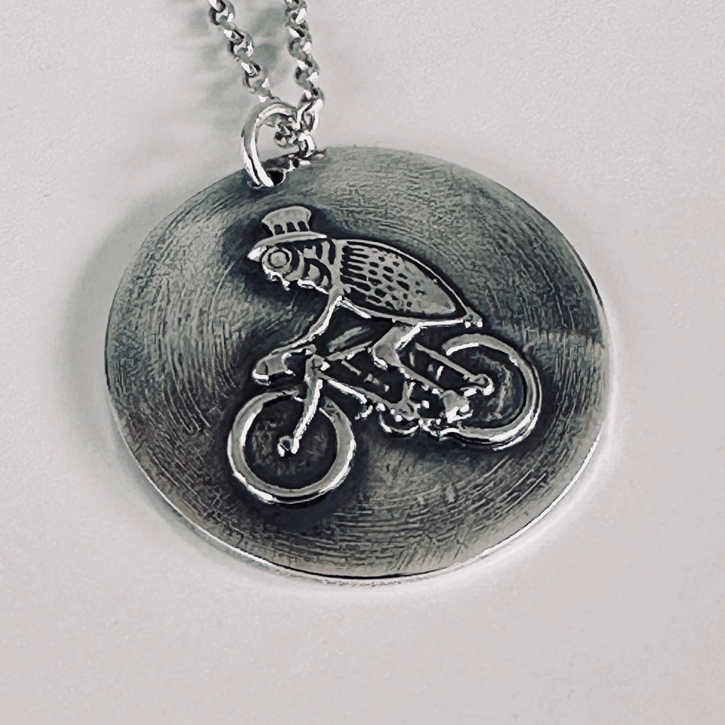 Sterling silver pendant with a flea on a bike wearing a top hat hamdmade by Bottlebee  who makes sustainable bespoke jewellery in Nottingham