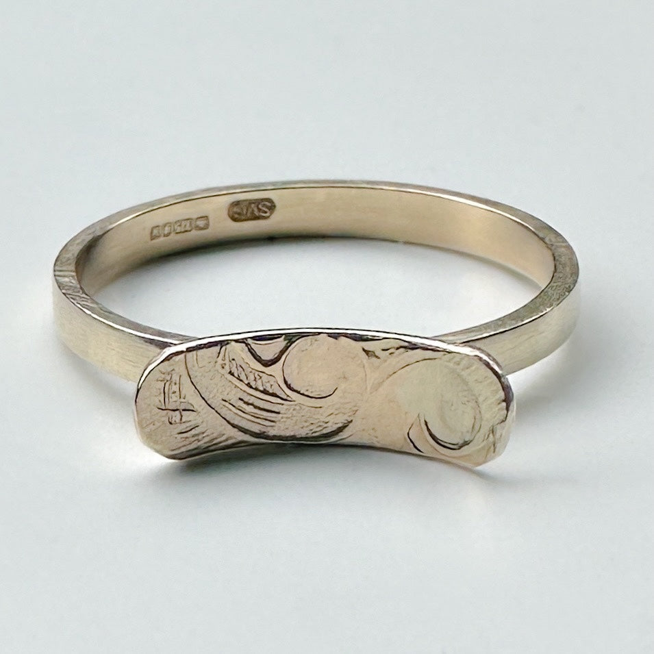 solid yellow 9ct gold engagement ring with engraved design on a light grey background