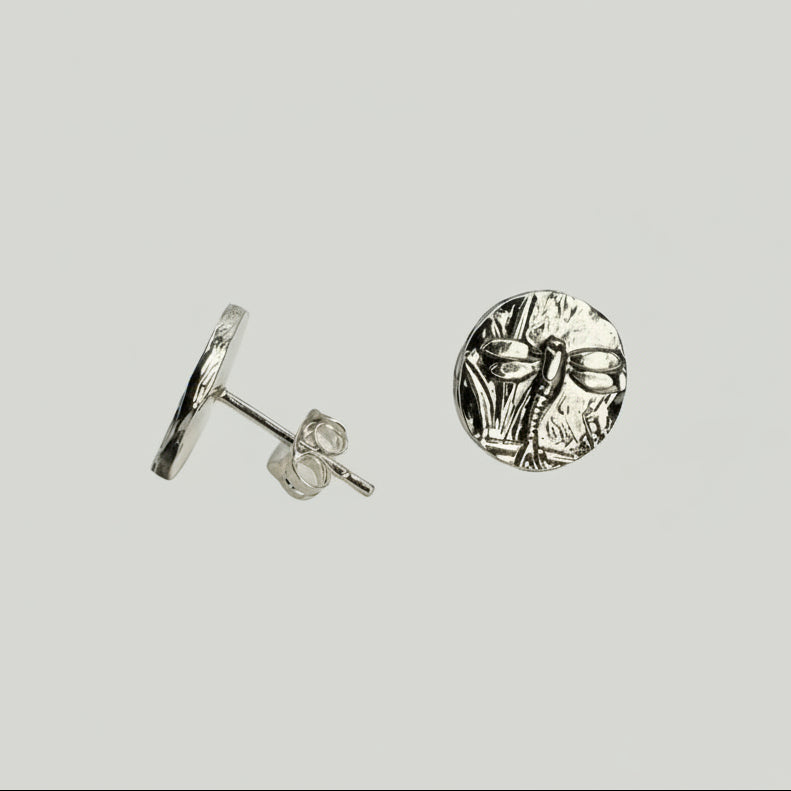 Small sterling silver round stud earrings with intricate and oxidised dragonfly designs on a white surface handmade by Bottlebee who makes jewellery in Nottingham, commissions are welcome