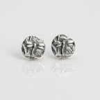 Small sterling silver round stud earrings with intricate and oxidised dragonfly designs on a white surface handmade by Bottlebee who makes jewellery in Nottingham, commissions are welcome