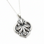 Solid sterling 925 silver wedding necklace with a black floral pendant on a light grey background sustainable jewellery nottingham