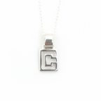 Silver geometric pendant on a white background with a thin delicate chain 