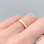 Solid gold skinny wedding ring on a woman's finger handmade in Nottingham by Bottlebee sustainable