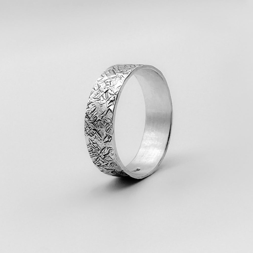 side view of a sterling sliver unique wedding band for man or woman with a hatch lined pattern made by Bottlebee in Nottingham with sustainable 925 solid silver