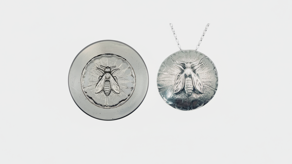 Silver bee pendant necklace on a white background