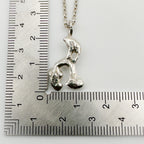 Silver pendant on a chain which has been sustainable made with recycled sterling silver next to a ruler for scale. Handmade bespoke jewellery in Nottingham