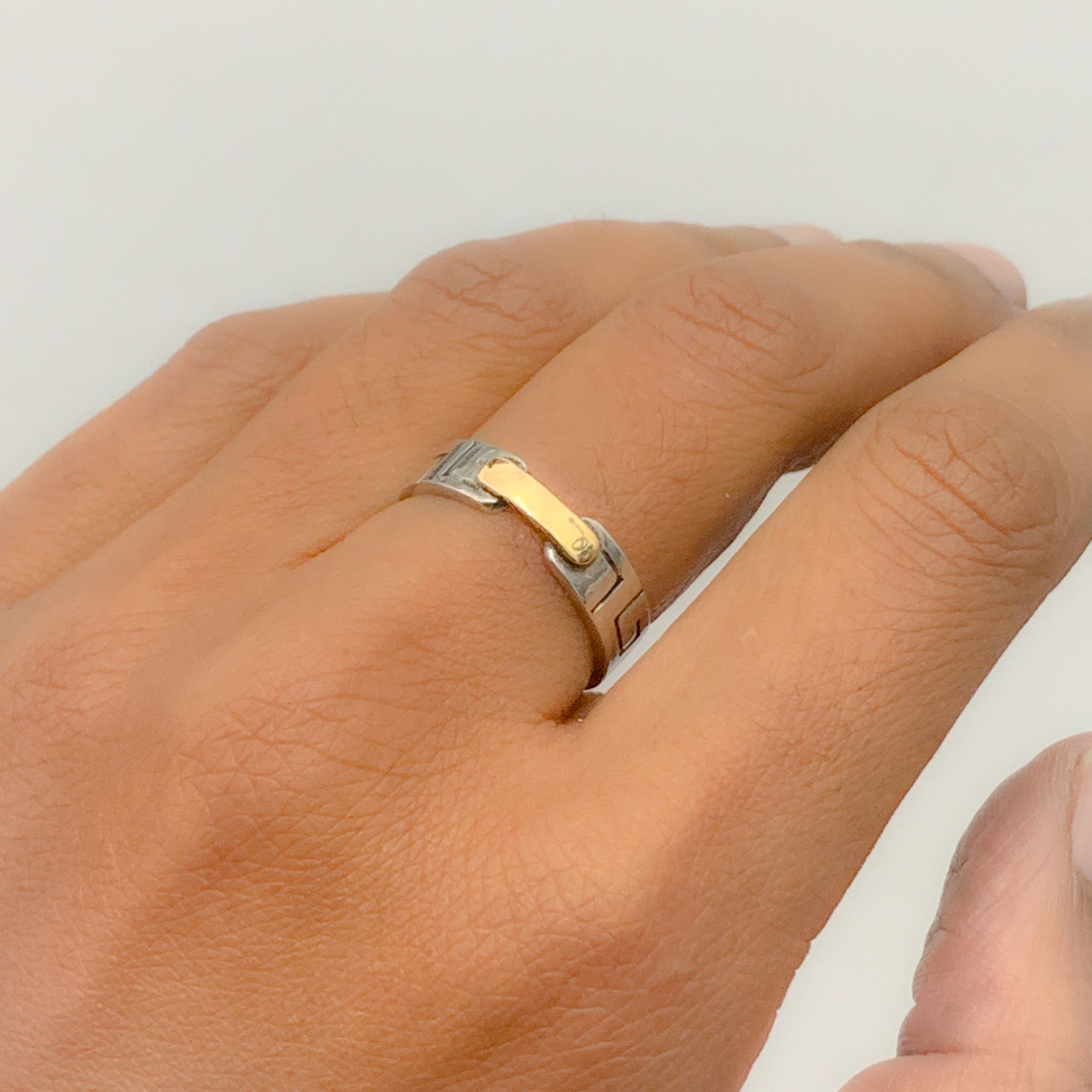 A sterling silver and gold ring worn on a finger handmade in Nottingham