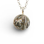 Silver necklace with a round pendant with a raised oxidised frog on a white background handmade by bottlebee in nottingham who makes sustainable jewellery