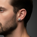 Close up of man wearing a handmade sterling silver stud earring with a skull design and oxidised. Handmade jeweller by Bottlebee, a small one-woman business in Nottingham who takes commissions