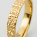 close up of a bark pattern on a solid 18ct gold wedding ring with bark textured band on a white background handmade Nottingham