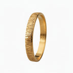 Solid gold wedding ring with a bark textured surface on a light background handmade by bottlebee in Nottingham who makes sustainable and bespoke jewellery