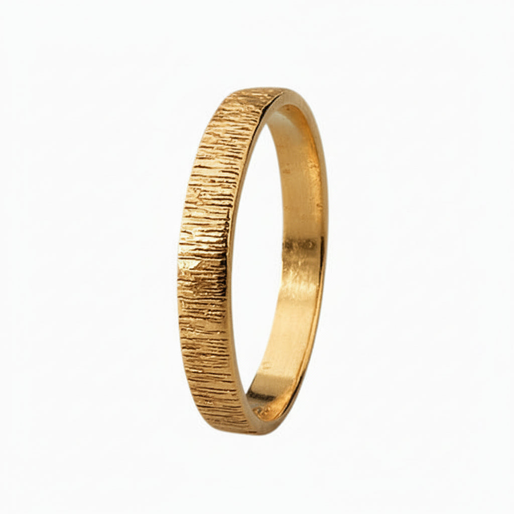 Solid gold wedding ring with a bark textured surface on a light background handmade by bottlebee in Nottingham who makes sustainable and bespoke jewellery