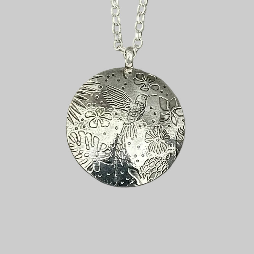 Silver pendant necklace with floral and bird design on a grey green background handmade by Bottlebee in Nottingham