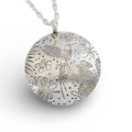 Silver pendant with floral and hummingbird designs on a white background, pendant made by hand by Bottlebee in Nottingham who makes bespoke sustainable unique jewellery