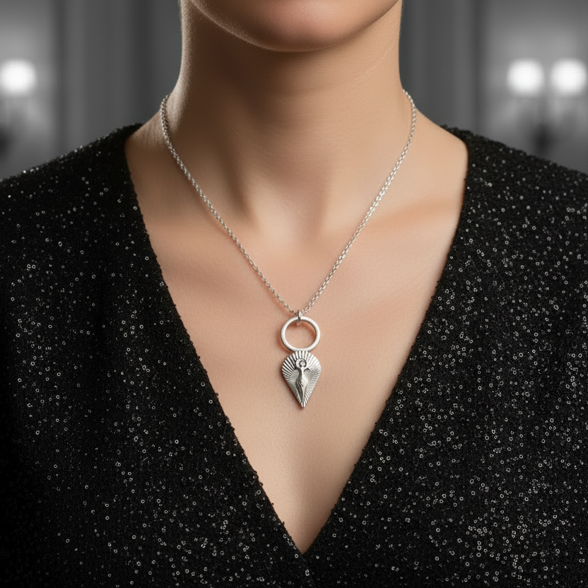 925 silver necklace with mother goddess pendant which is a a symbol of feminine power, protection, and spiritual connection worn by a woman in a black textured top against a blurred background