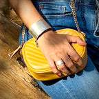 Woman wearing Bottlebee handmade silver cuff and ring holding a yellow handbag