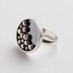Silver ring with embedded silver balls on a light grey background handmade sustainably in Nottingham