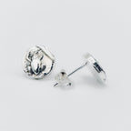 Silver round earrings with a frog impression on a light grey background