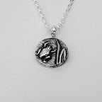 Silver pendant necklace with a detailed frog design on a light grey background handmade by Bottlebee who makes bespoke sustainable jewellery in Nottingham