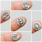 Silver insect-themed patterns called Pond Life held on fingers on a light grey background.  Bottlebee in Nottingham can make any pieces of jewellery with these 5 impressions.