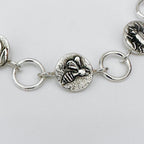 Close-up of a silver bracelet with bee charm on a light grey background made in Nottingham by Bottlebee who mades jewellery that is sustainable