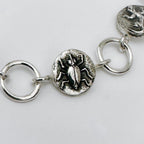 Close-up of a silver bracelet with beetle charm on a light grey background made in Nottingham by Bottlebee who mades jewellery that is sustainable