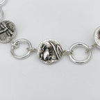 Close-up of a silver bracelet with from charm on a light grey background made in Nottingham by Bottlebee who mades jewellery that is sustainable