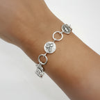Silver bracelet with circular charms and round links on a wrist against a white background Nottingham jewellery sustainable