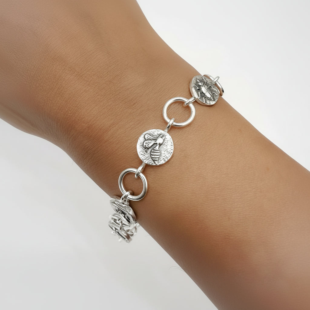 Silver bracelet with circular charms and round links on a wrist against a white background Nottingham jewellery sustainable