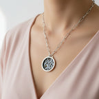 Woman in a pink v neck top wearing a sterling silver and 18ct gold necklace with a silver paperclip chain which has been made with sustainable practices by Bottlebee in Nottingham who makes bespoke jewellery