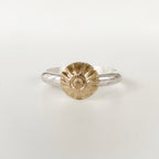Face on view of silver ring with a gold center on a light grey background can be alternative engagement ring