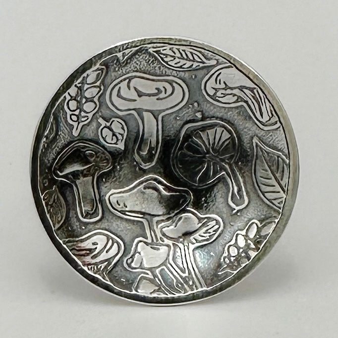 close up of silver mushroom statement ring showing different mushrooms and leaves handmade by small business nottingham