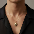 man in a black shirt wearing a solid gold skull pendant necklace handmade by Bottlebee in Nottingnham