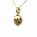 Gold skull pendant necklace on a light background handmade in Nottingham by Bottlebee