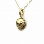 Gold skull pendant necklace on a light background handmade in Nottingham by Bottlebee
