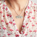 Woman in a pink flamingo shirt wearing a handmade in nottingham by a bespoke jeweller silver and gold necklace with a paperclip chain